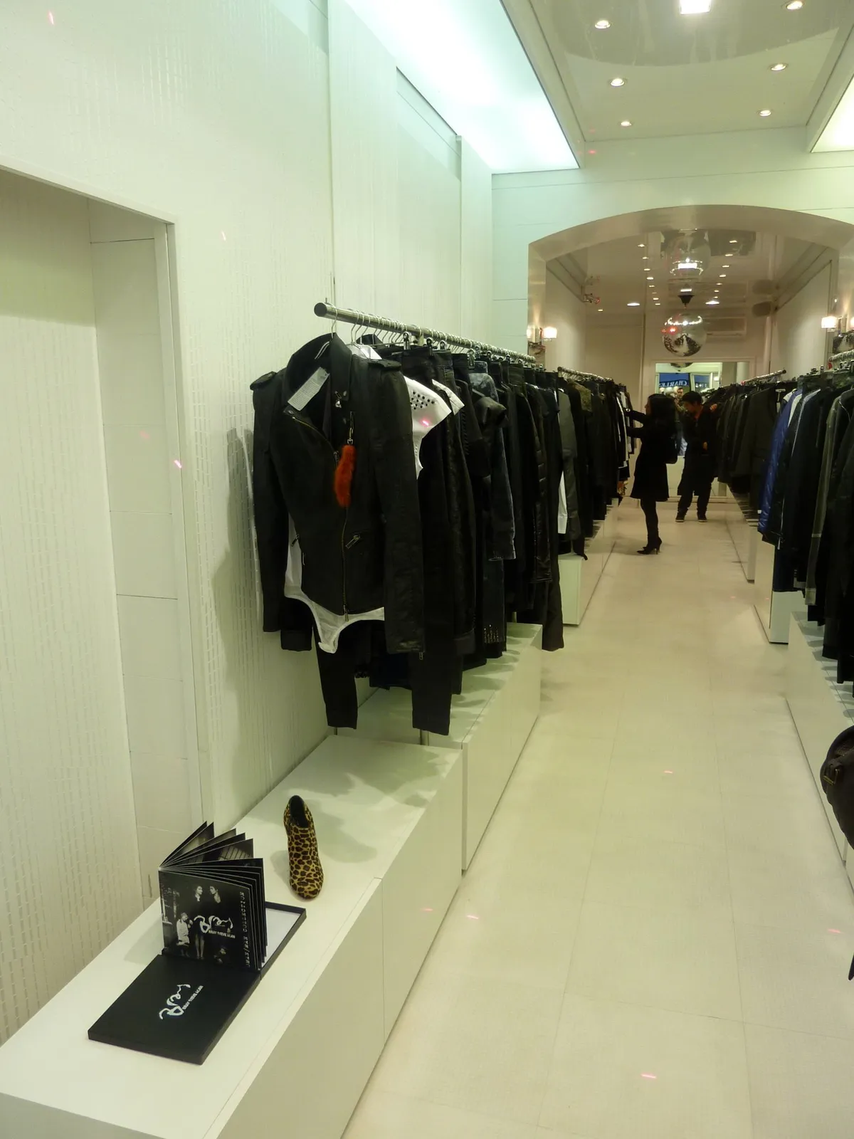 Allée centrale de la boutique bordée de portants