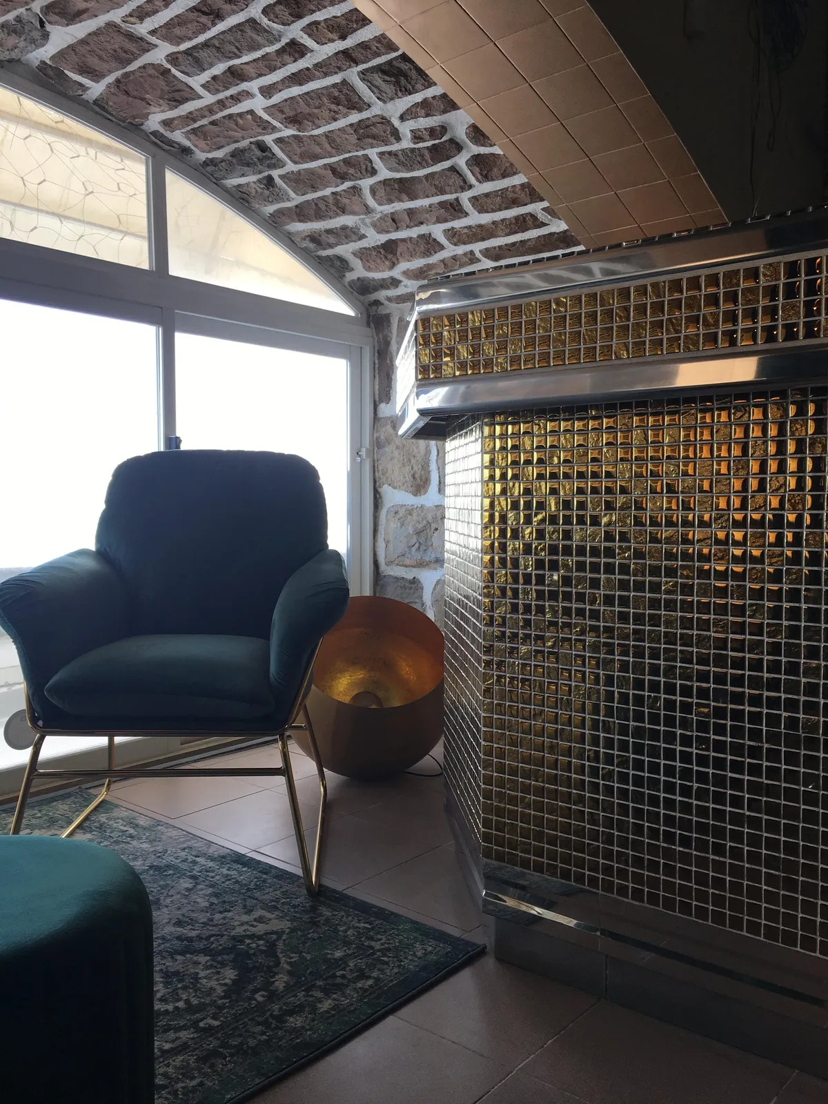 Bar habillé de mosaïque dorée, fauteuil en velours vert