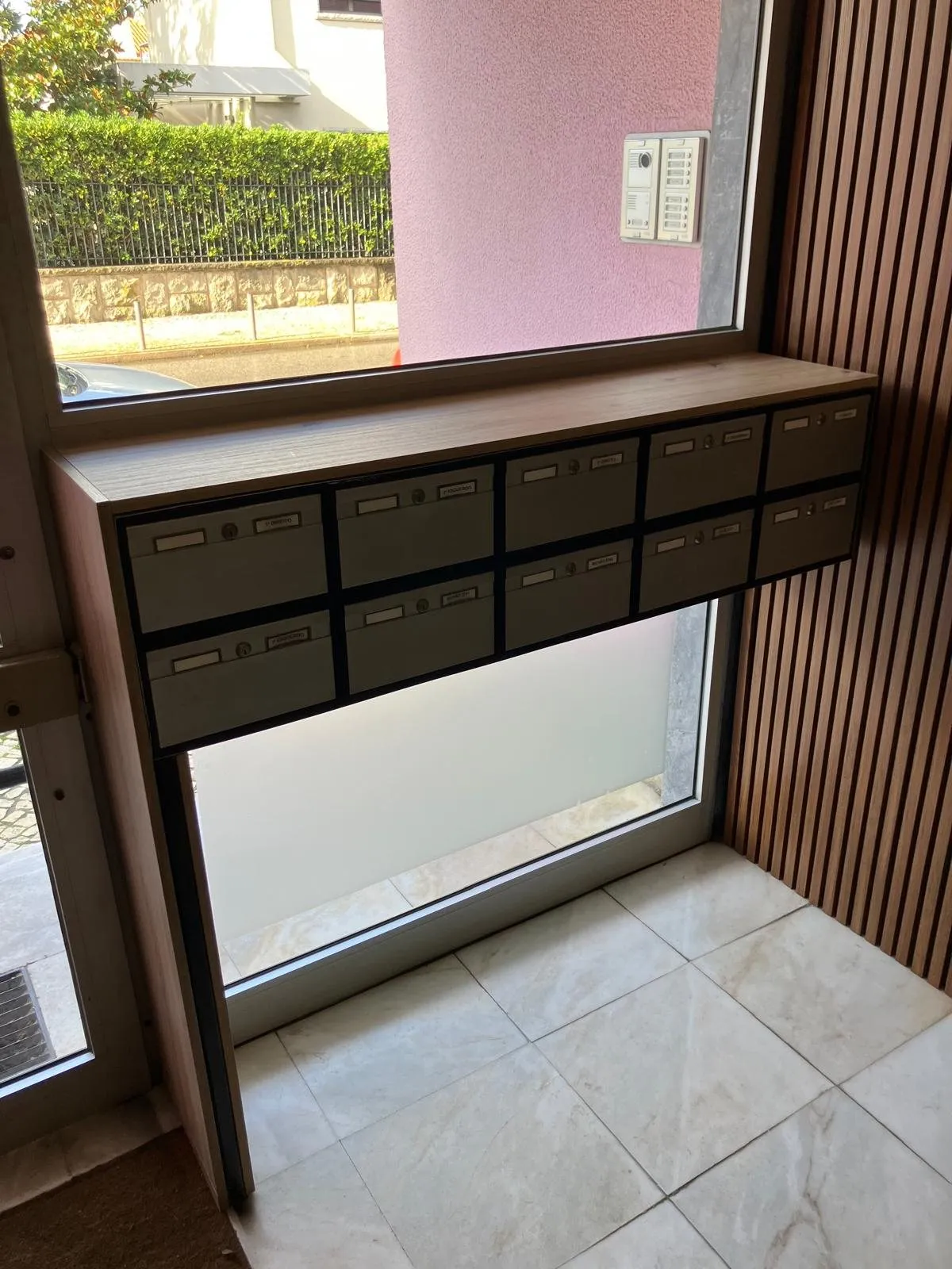 Nouveau meuble de boîtes aux lettres en bois devant la baie vitrée