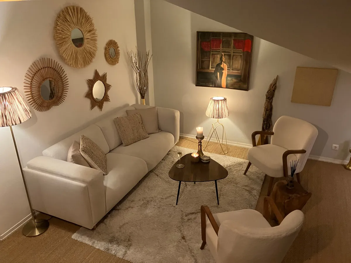 Salon sous les toits, canapé écru, fauteuils bouclette et miroirs soleil en fibres naturelles