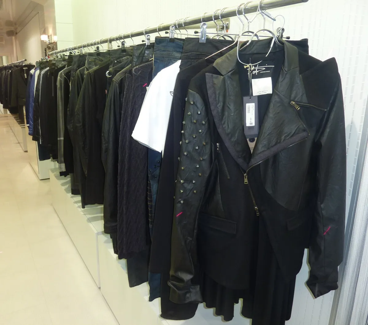 Long portant de vestes en cuir et en laine le long d'un mur blanc