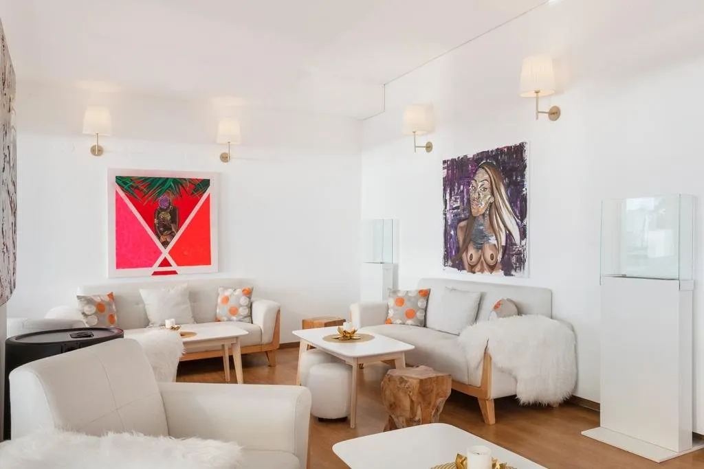 Salon blanc et bois, œuvres d'art colorées aux murs