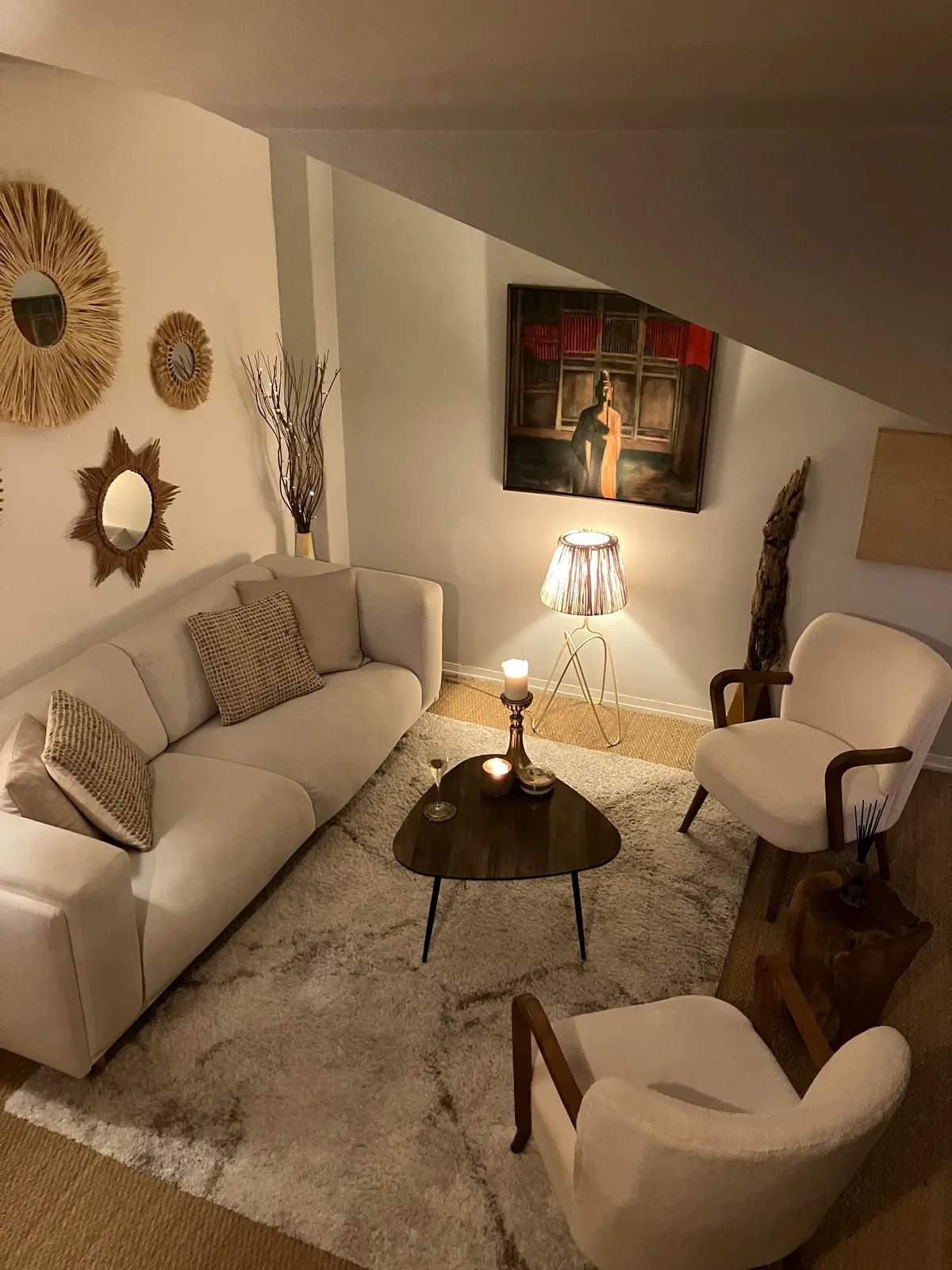 Canapé écru, table basse en bois sombre et fauteuils bouclette