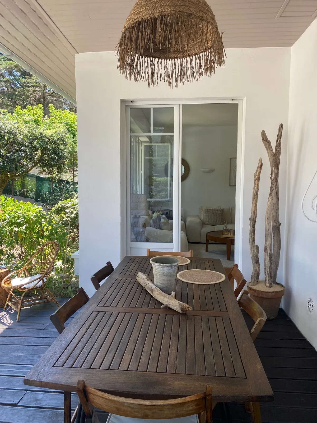 Grande table en bois sous l'auvent de la terrasse
