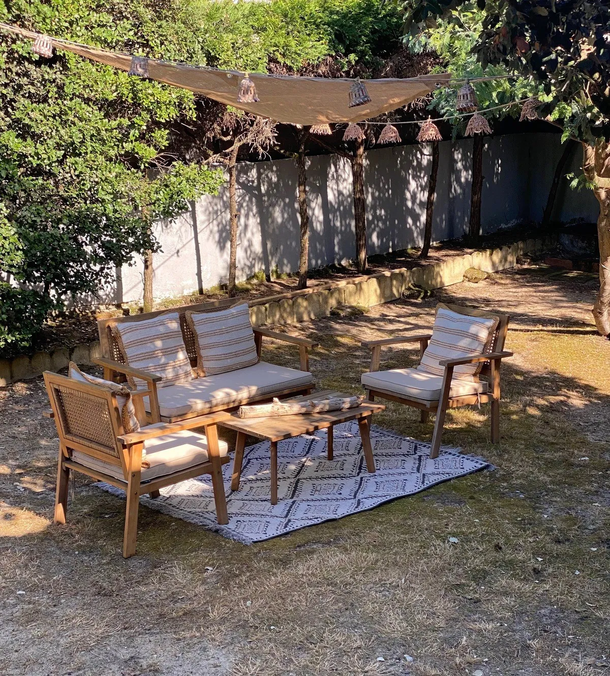 Salon de jardin abrité sous une voile d'ombrage