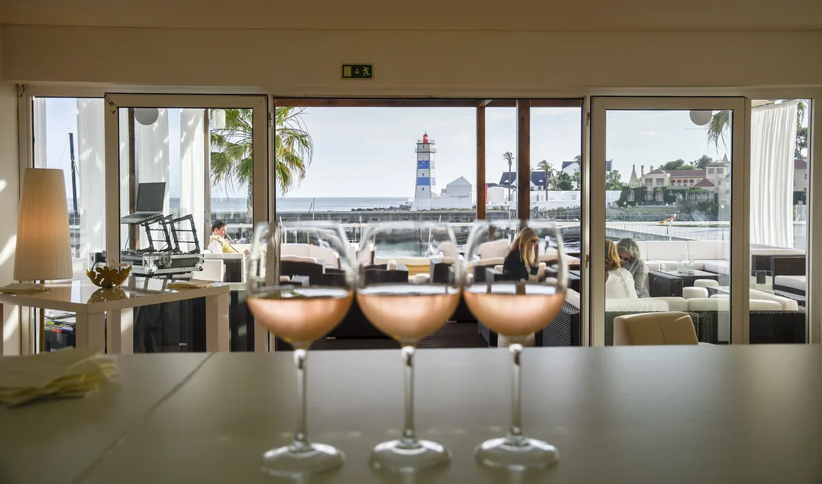 Trois cocktails sur le comptoir, avec le phare et la marina en arrière-plan